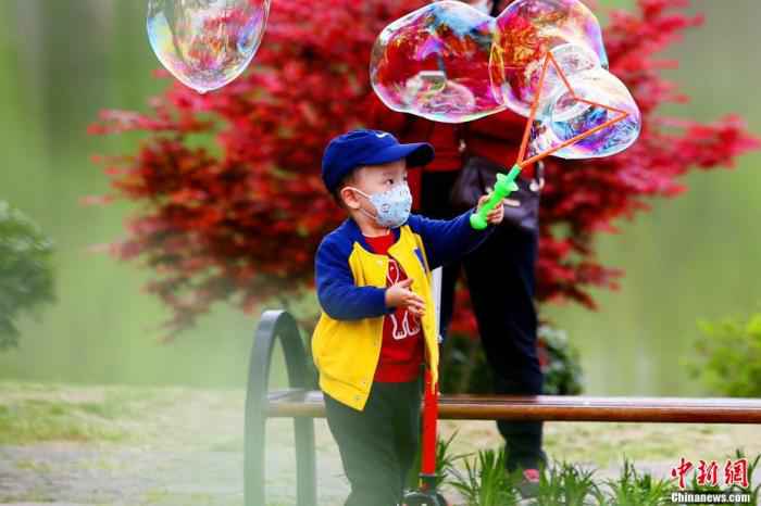 资料图:逐渐恢复活力的武汉,小男孩在东湖边开心玩耍。 王康荣 摄 武汉静待“解封”:终有归期 不忘相约